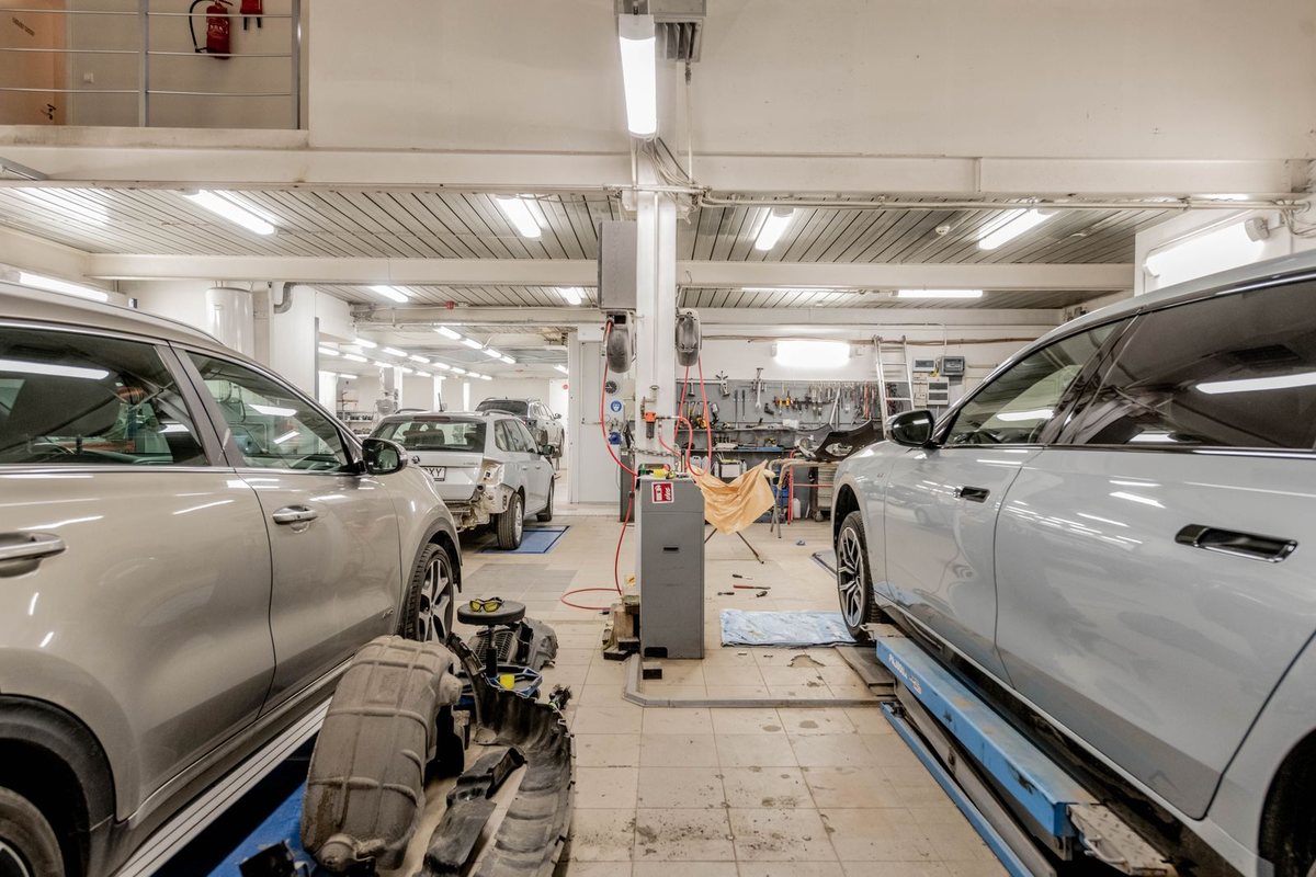 A technician pulling a dent on a car body panel
